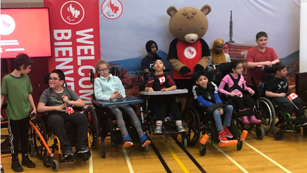 A group of students with a teddy bear mascot